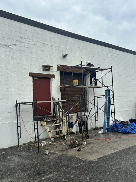 Emergency exit opening with masonry removed above the head, scaffold and shoring set