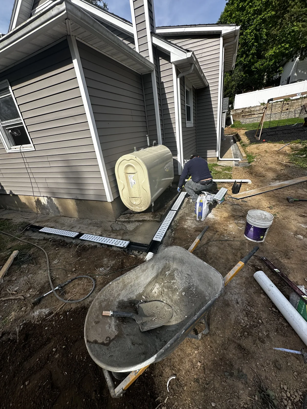 Residential exterior utility and drainage work beside the house