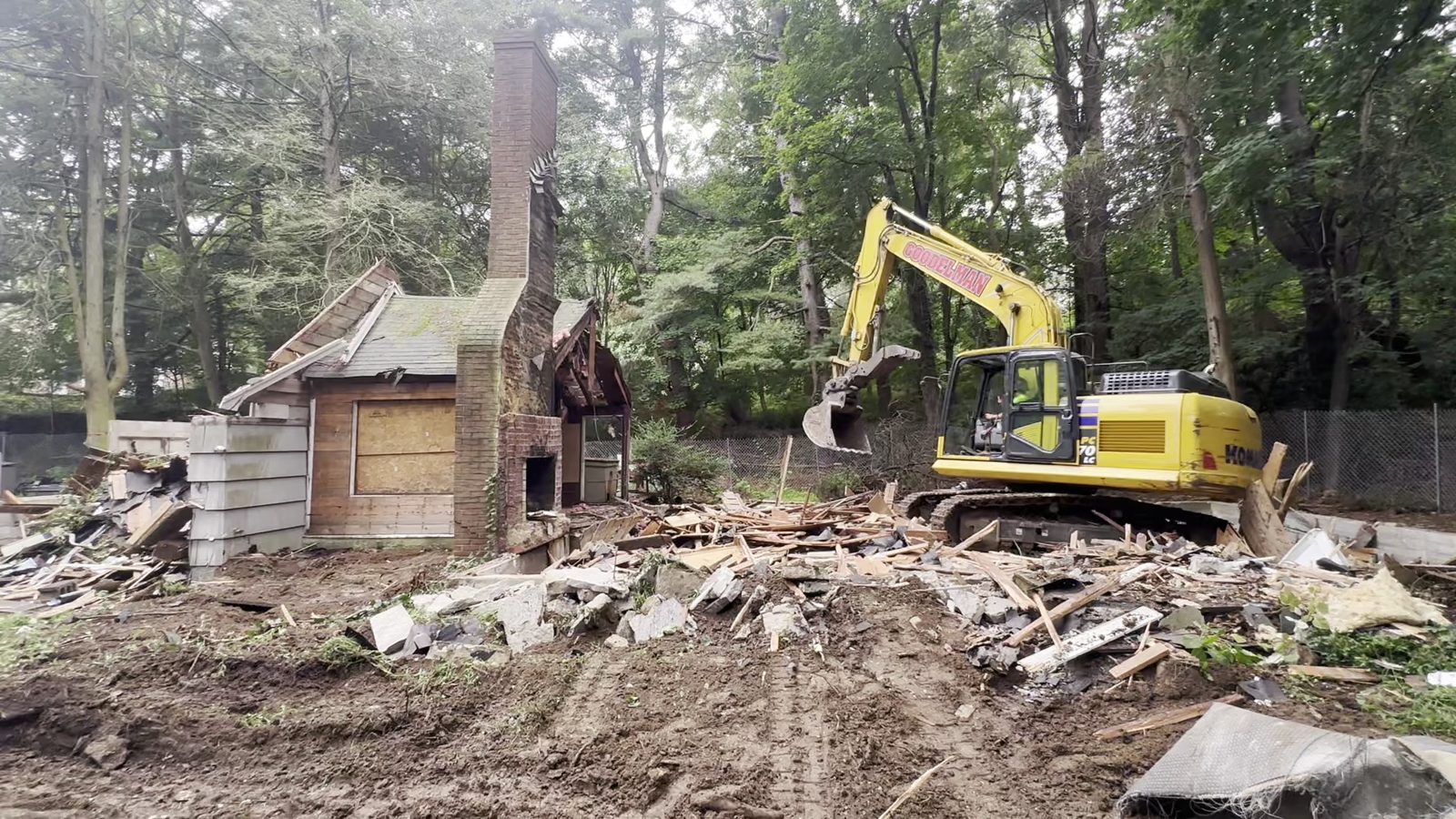Excavator taking down the existing house in Woodbury, August 2026