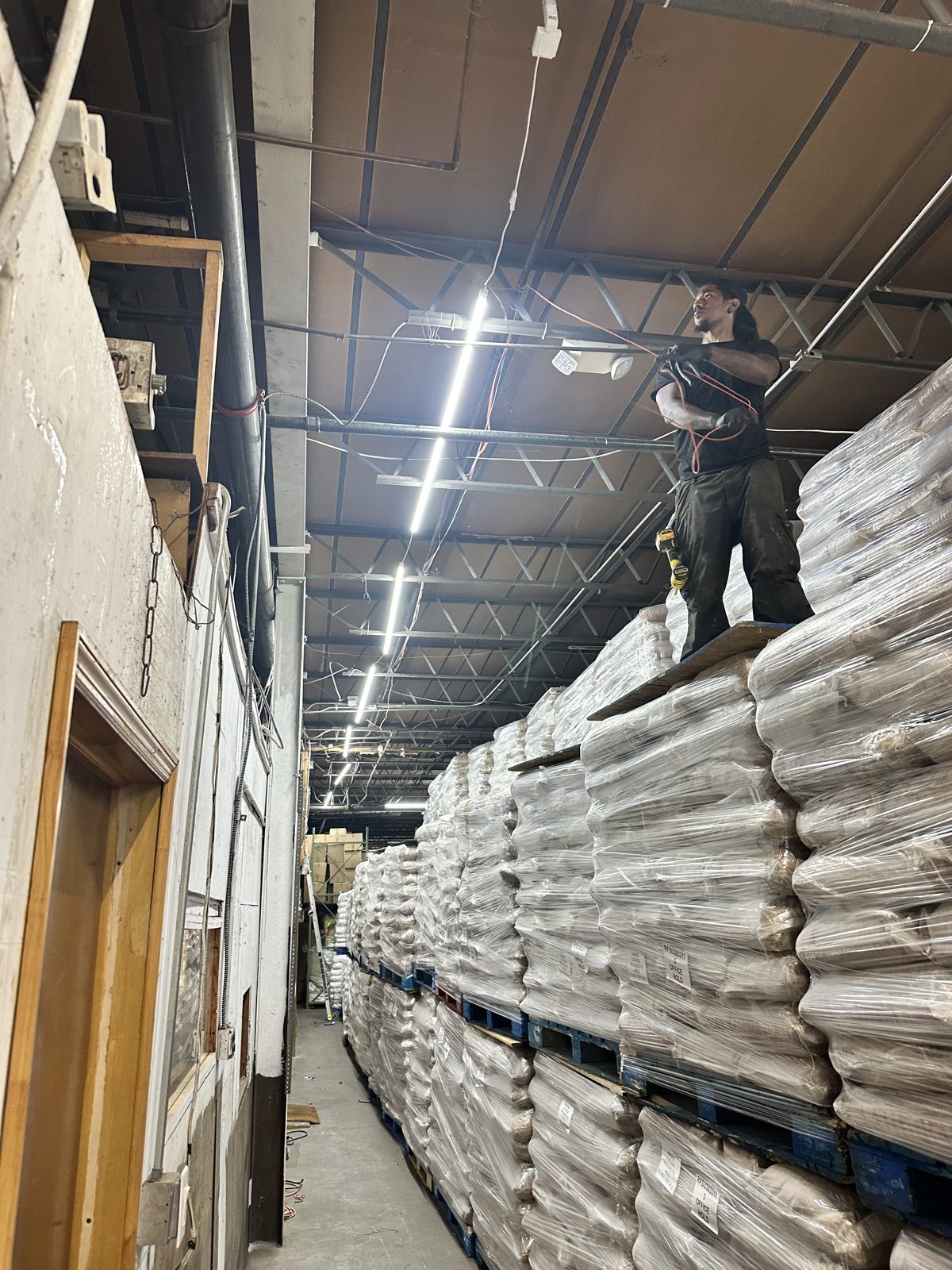 Lighting repair from a lift over loaded pallet racking while the warehouse stayed in operation